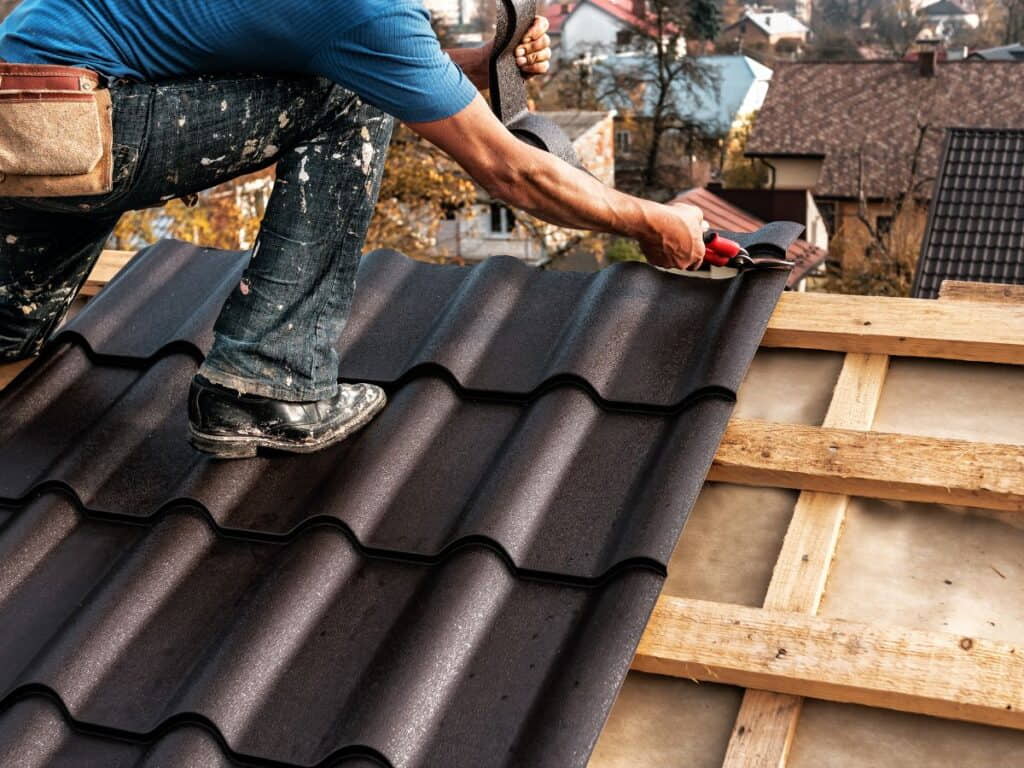 Roofer doing roof repair on a tile roofing structure