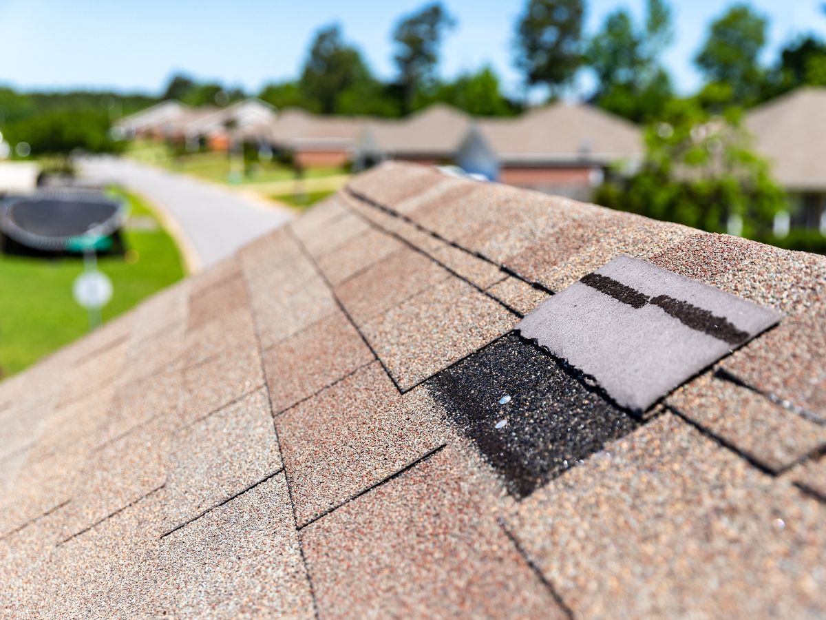 Roof with missing shingles on a suburban home