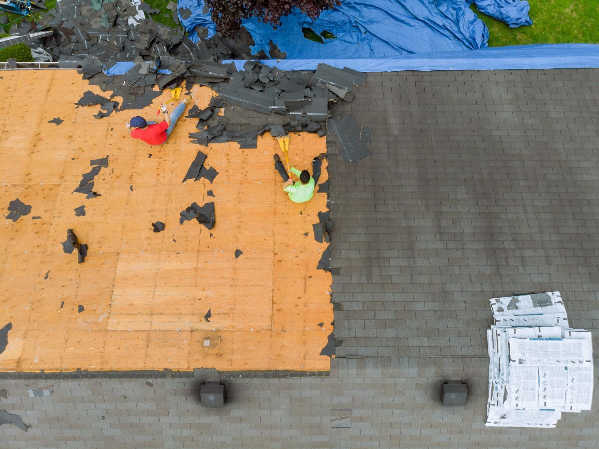 Roofers repair missing shingles on residential roof
