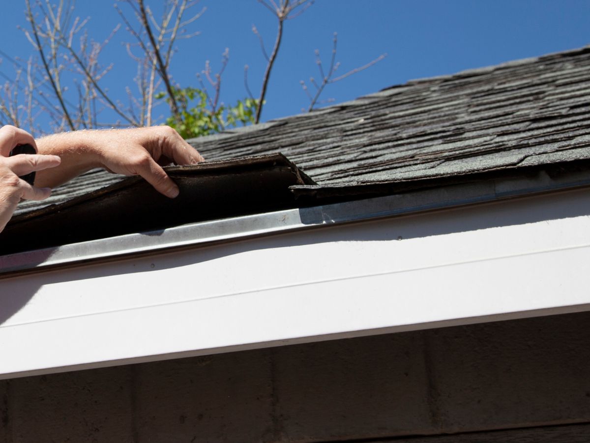 Repairing missing shingles on home roof edge
