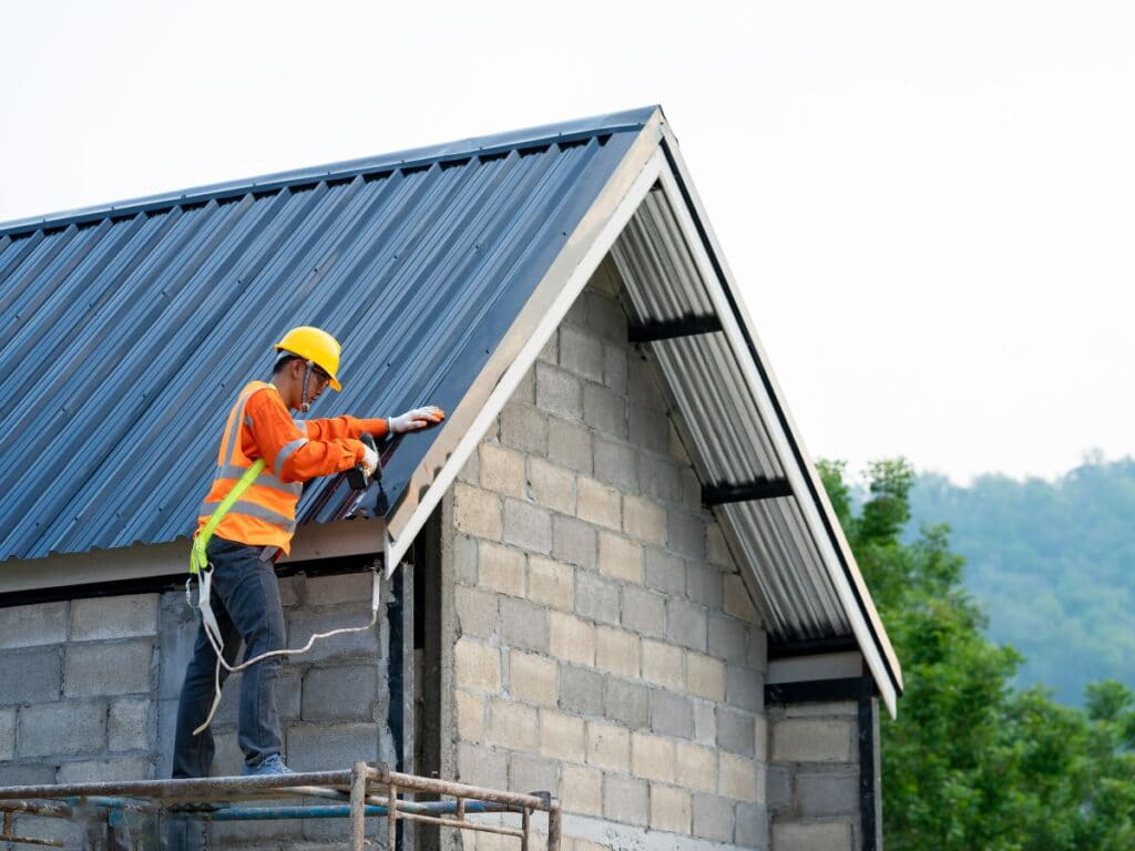 Roofer performing roof maintenance on a metal roof