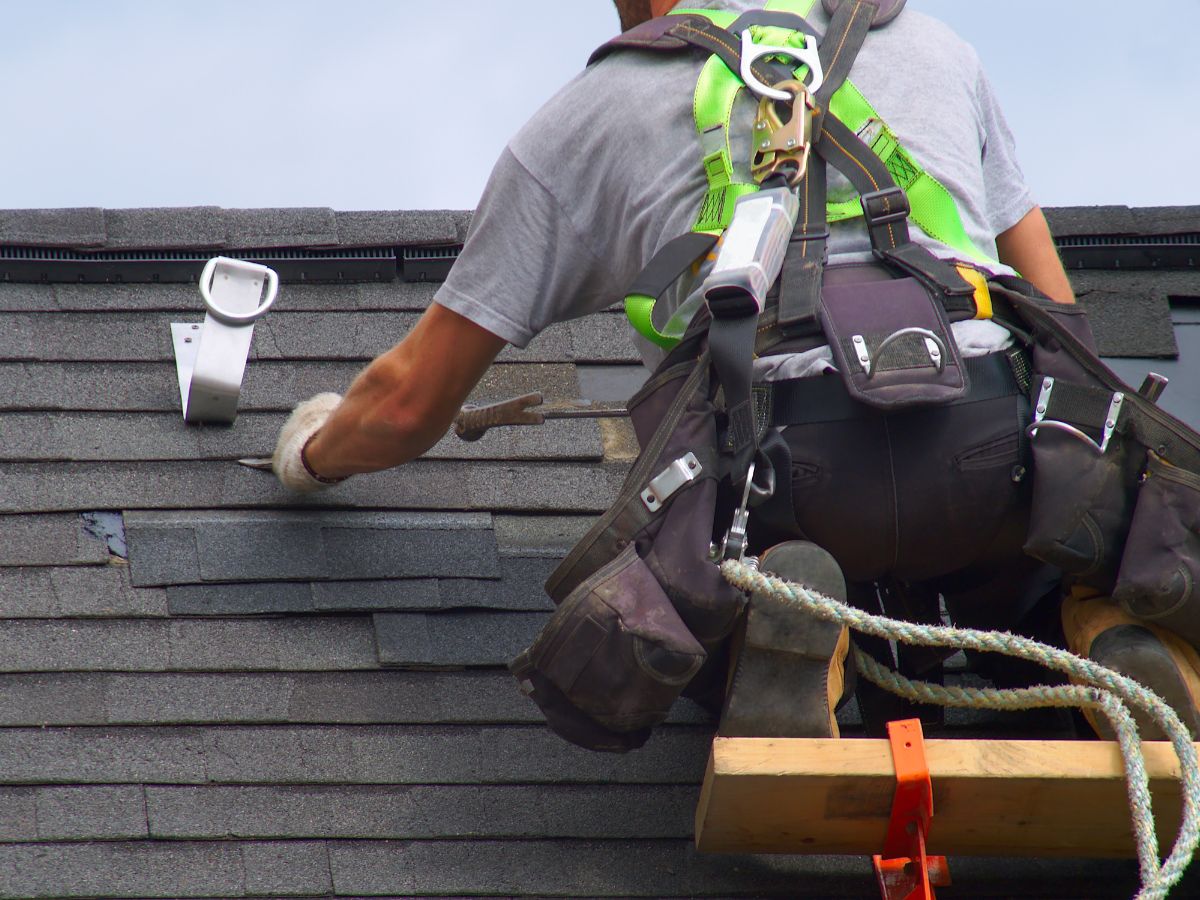 Roofer sealing the missing shingles for protection